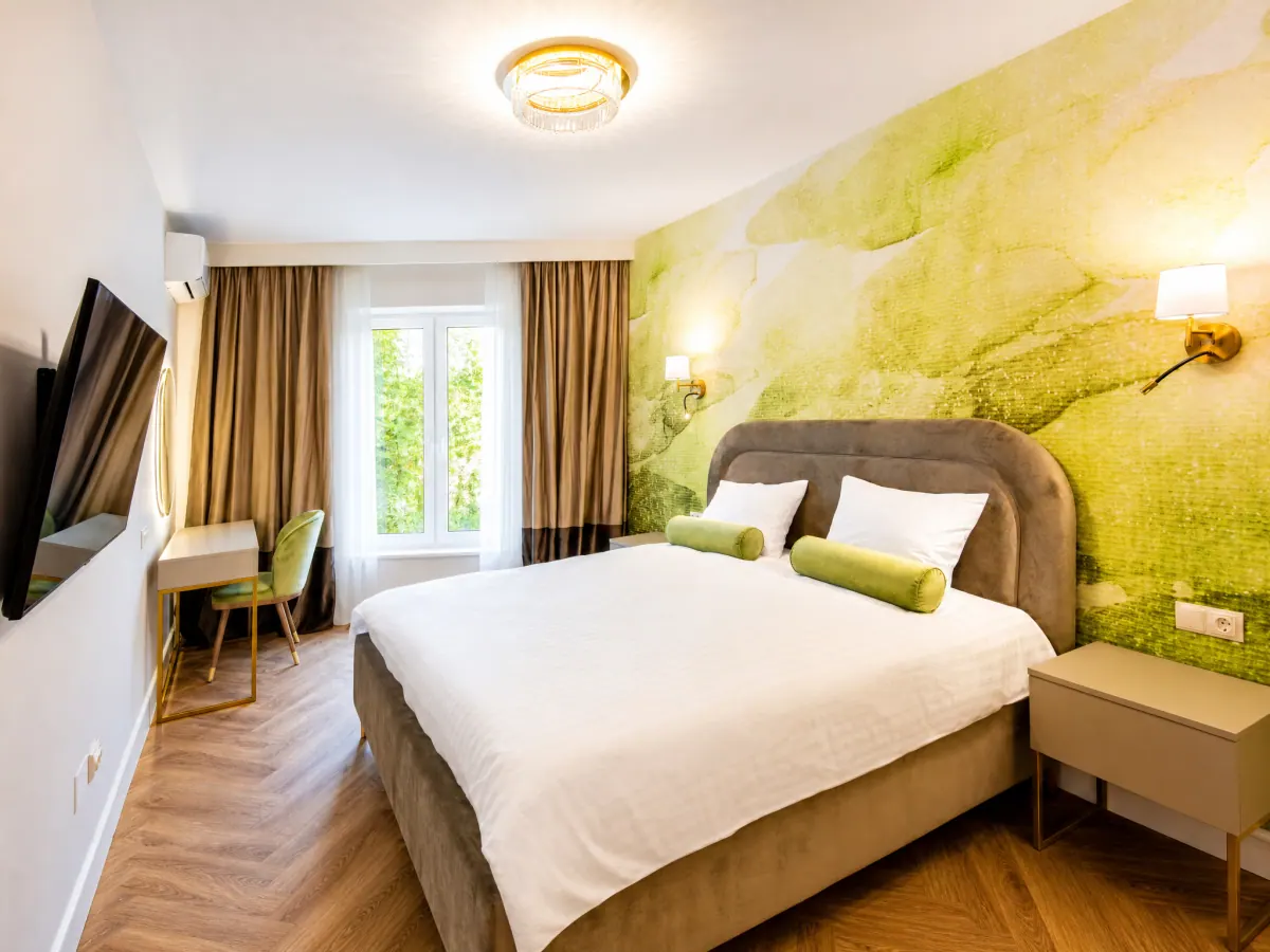 Dormitor cu pat matrimonial și tapet verde în Siago Apartments, cu vedere spre oraș
