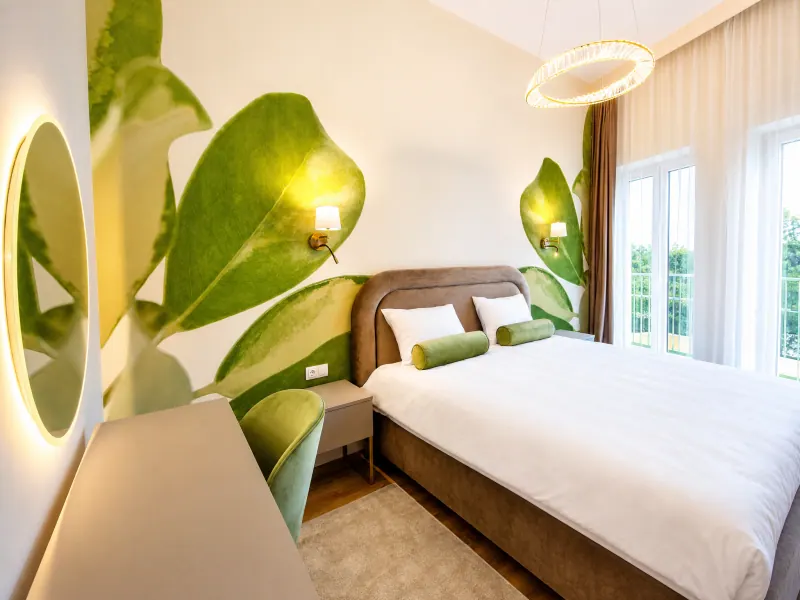 Dormitor cu pat matrimonial și decor botanic în Siago Apartments, Cluj-Napoca