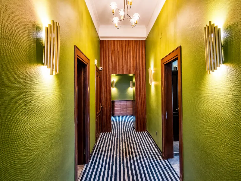 Corridoio con pareti verdi e applique dorate a Vila Siago, Cluj-Napoca